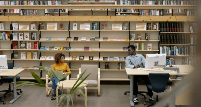 two people looking at each other across a library